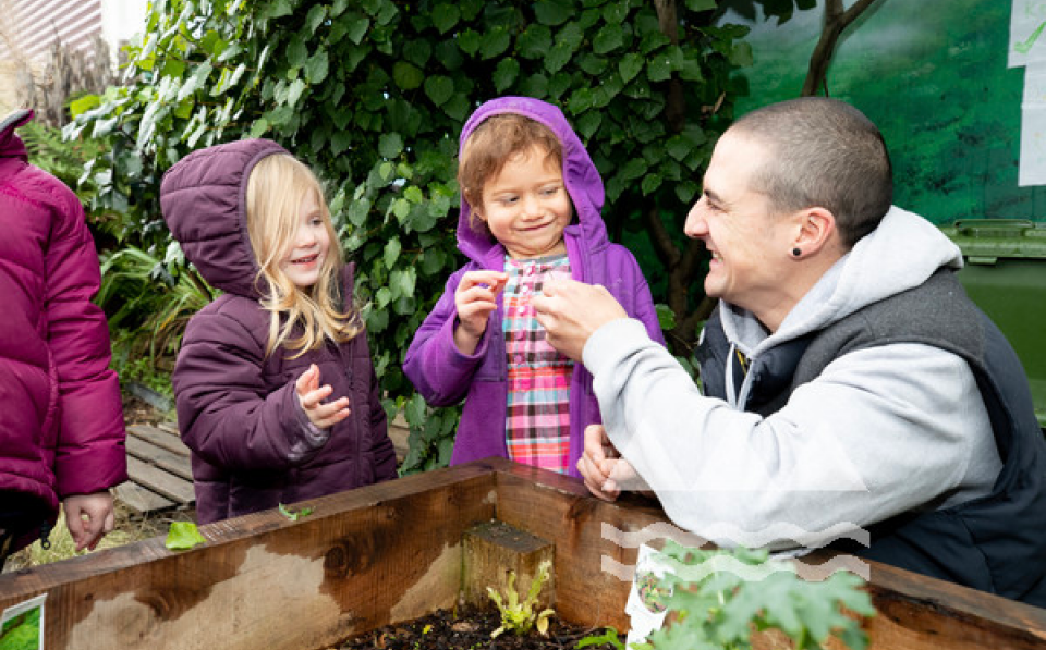 Teacher playing with children over garden