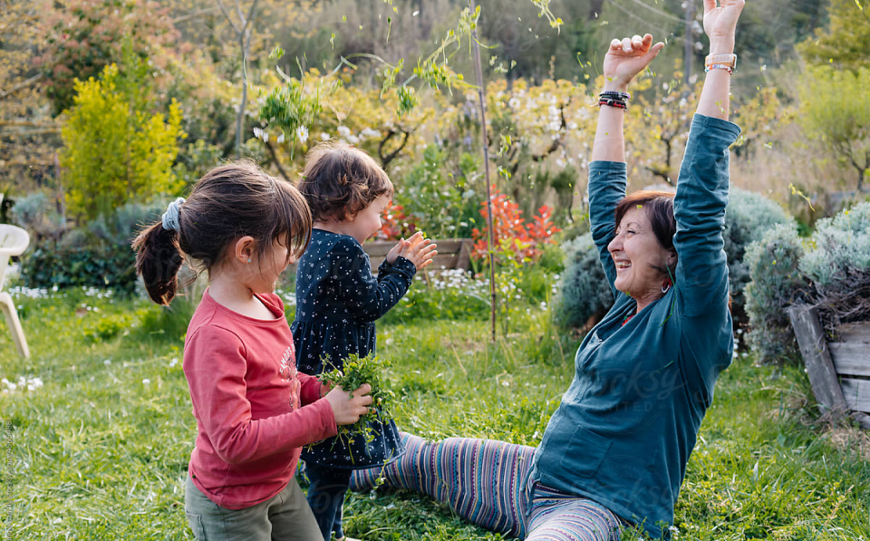 teacher playing outside with two young children