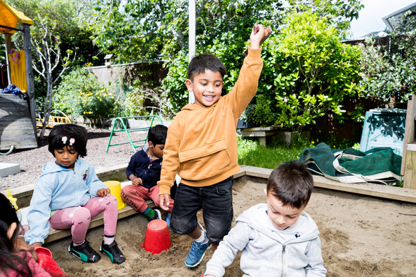 Child dancing in a sandpit
